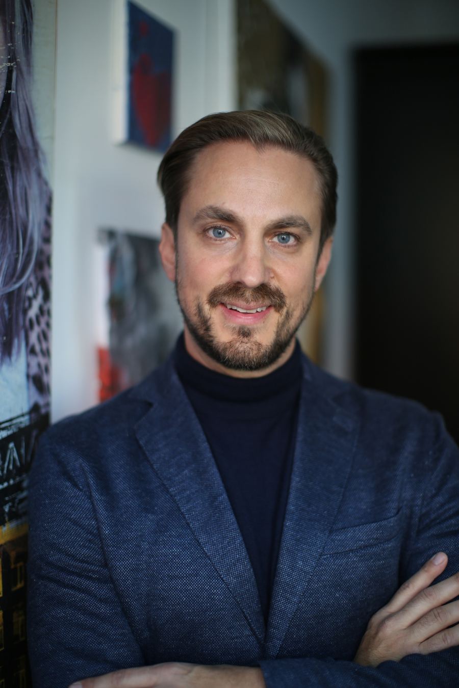 Jörg H. Kübler im Studio vor Filmplakaten